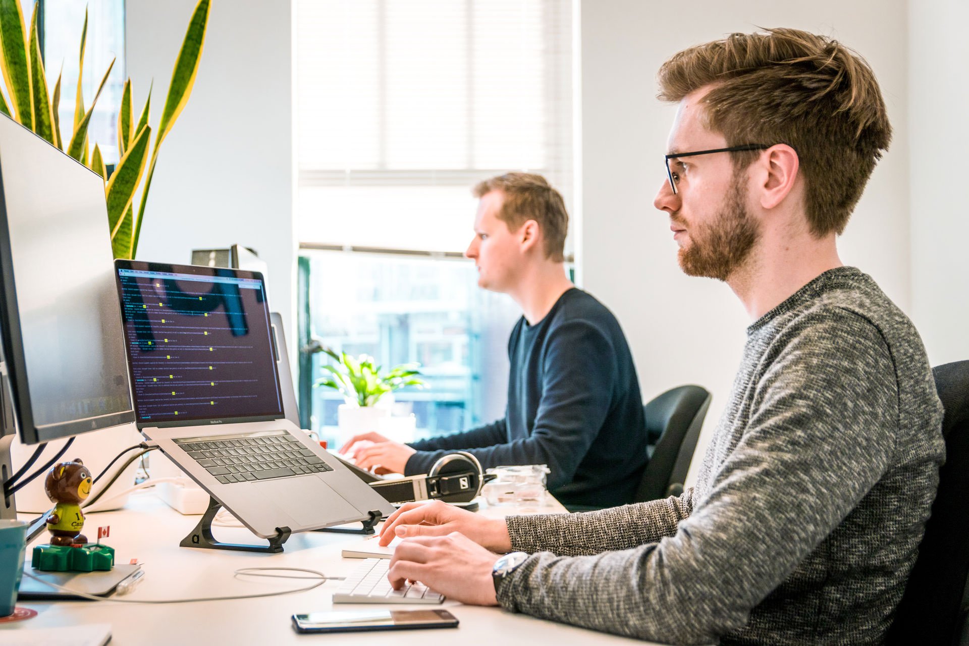 Two men sitting in front of computer screens